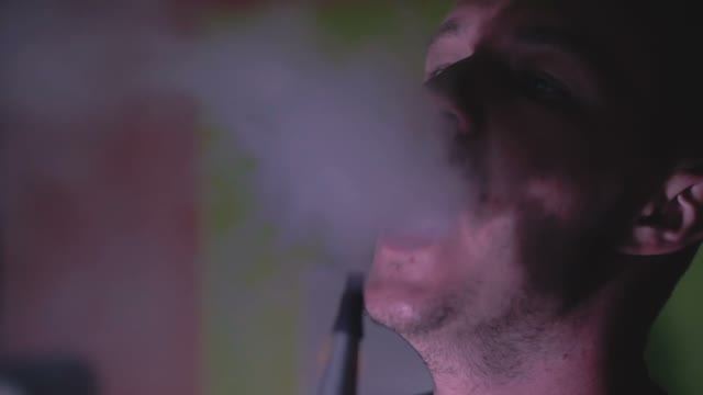 Man Exhales Smoke From A Hookah Close-up