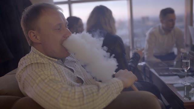 Man Smokes A Hookah In A Restaurant Close-up
