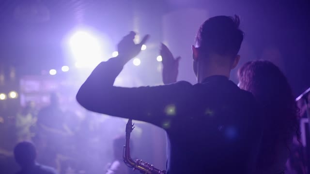Man With A Saxophone Applauds On Stage Close-up