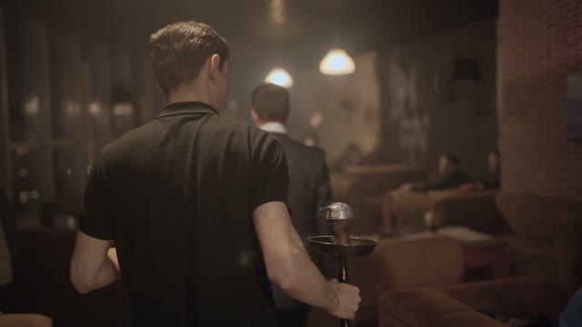 Man Carries A Hookah For Guests