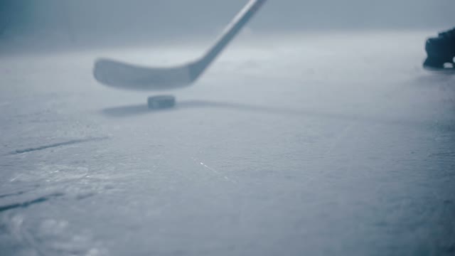 Hockey Player Hits The Puck With A Stick Close-up