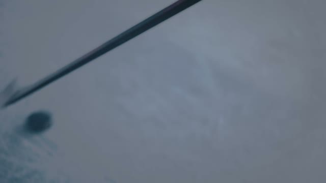 Hockey Player Hits The Puck With A Stick Close-up
