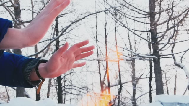 A Man Warms Himself In The Winter By The Fire