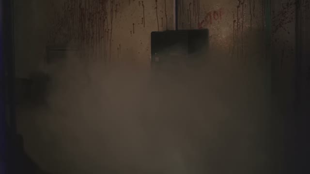 Maniac Killer Walks Through A Room Full Of Smoke And Walls Washed With Blood