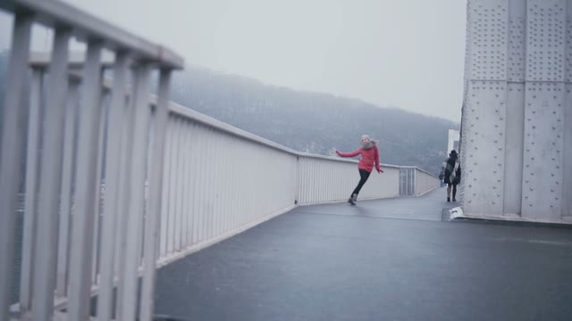Young Charming Girl Cheerfully Runs Along The Bridge