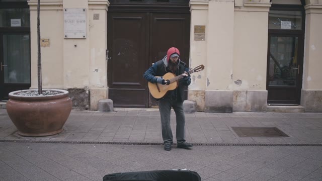 An Elderly Man Playing A Guitar For People Dancing Around