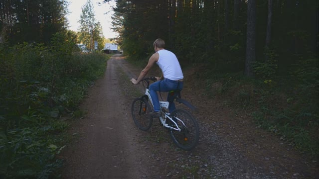 Young Man Riding A Bicycle In The Forest