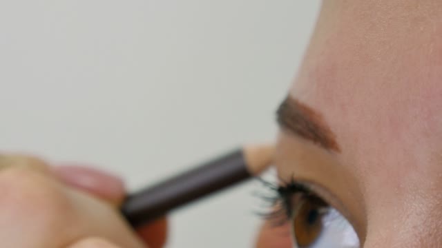 Master Paints The Eyebrow Of A Girl Close-up