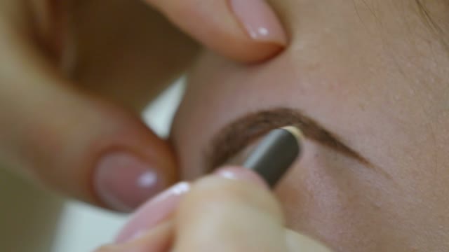 Master Paints The Eyebrow Of A Girl Close-up