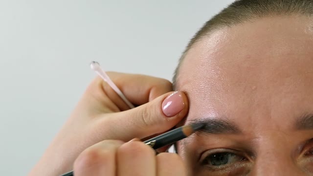 Girl Paints A Man's Eyebrow Close-up