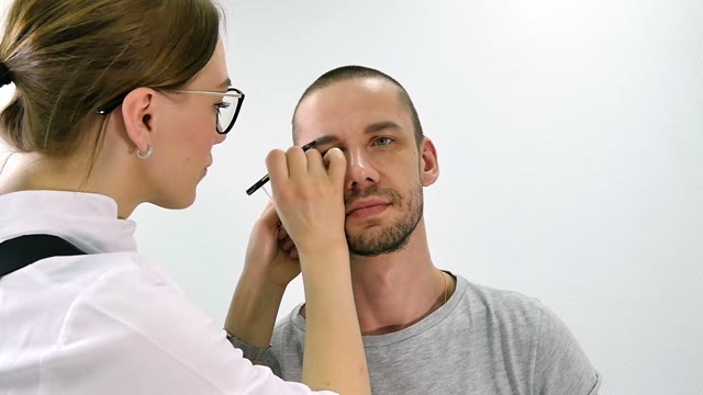 Girl Paints A Man's Eyebrow Close-up