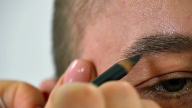 Girl Paints A Man's Eyebrow Close-up