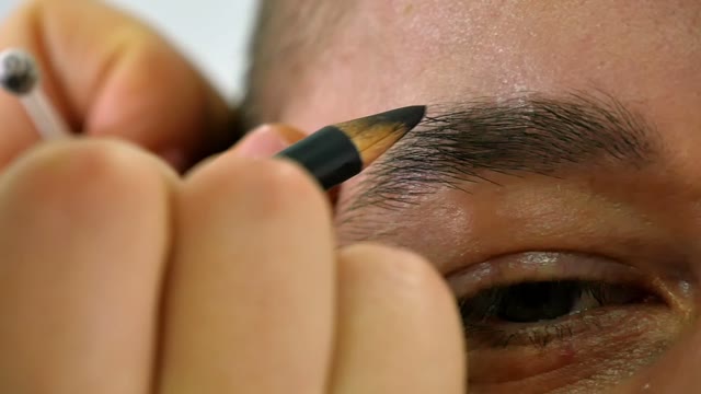 Girl Paints A Man's Eyebrow Close-up