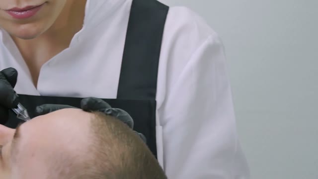 Woman Does Tattoo Of Man's Brows Close-up