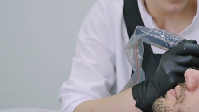 Master Does Tattoo Of Man's Brows Close-up