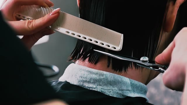 Hairdresser Cuts Hair To The Client Close-up