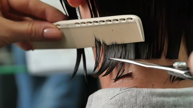 Hairdresser Cuts Hair To The Client Close-up