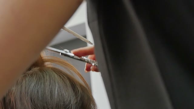 Hairdresser Cuts Hair To The Client Close-up
