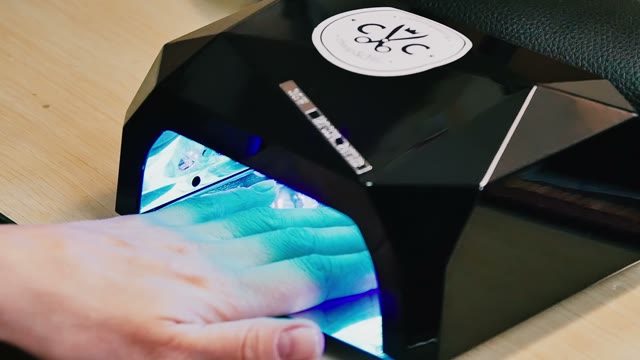 Female Hand In Lamp For Manicure Close-up
