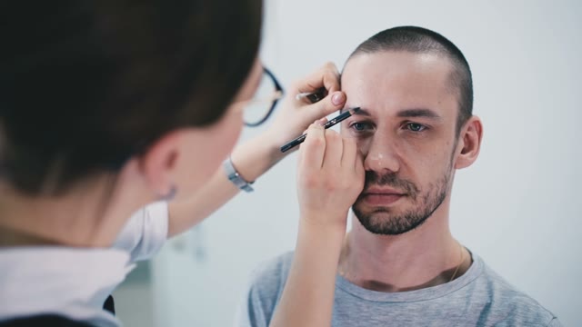 Girl Paints A Man's Eyebrow Close-up