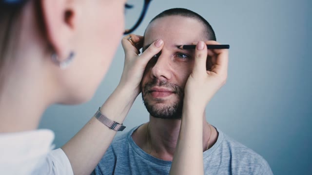 Girl Paints A Man's Eyebrow Close-up
