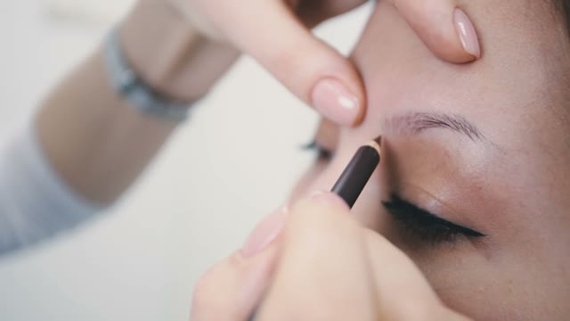 Master Paints The Eyebrow Of A Girl Close-up