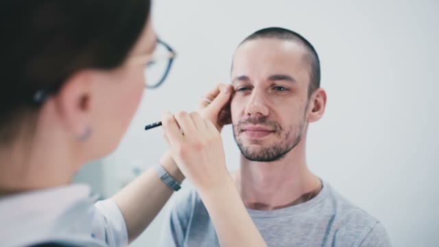 Girl Paints A Man's Eyebrow Close-up