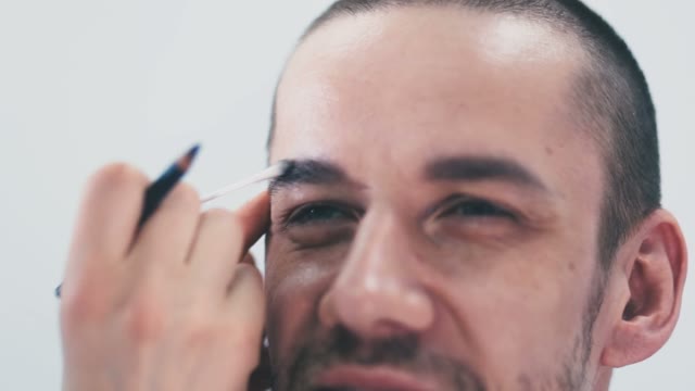 Girl Paints A Man's Eyebrow Close-up