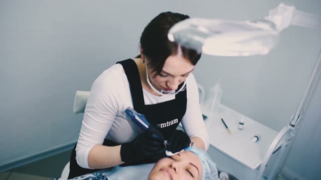 Woman Does Tattoo Of Eyebrows Close-up