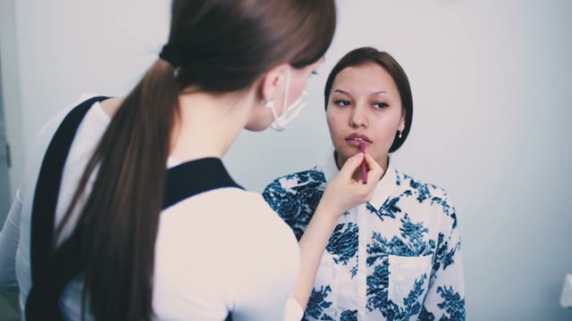 Girl Paints A Womans's Lips Close-up