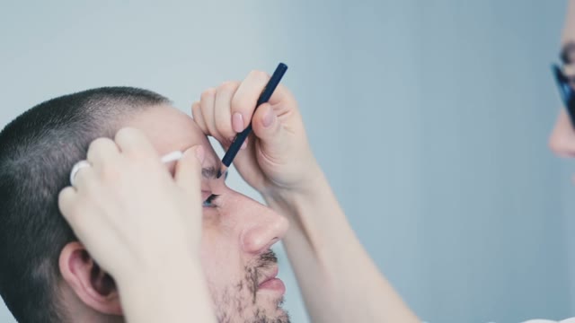 Girl Paints A Man's Eyebrow Close-up