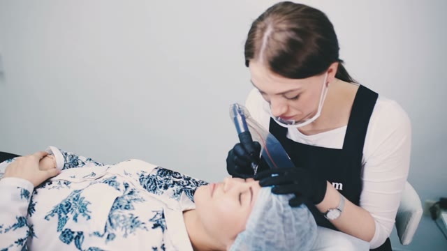 Woman Does Tattoo Of Eyebrows Close-up