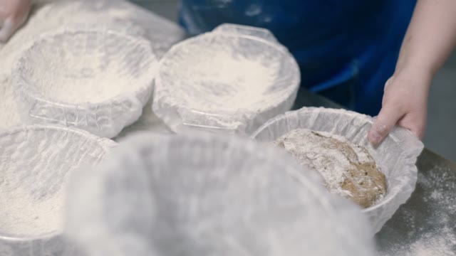 Woman Puts Black Dough In Baskets