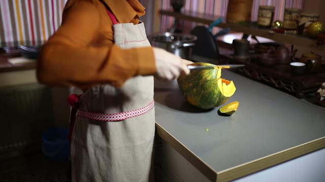Woman Is Cutting A Pumpkin