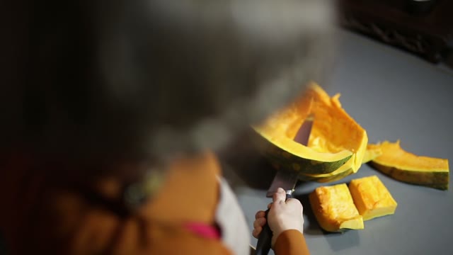 Woman Cuts A Pumpkin Into Slices