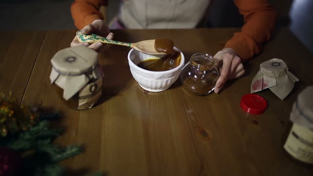 Woman Puts Honey In A Jar
