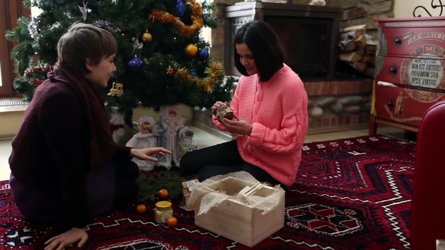 Girls Sit On The Floor And Pack A Gift