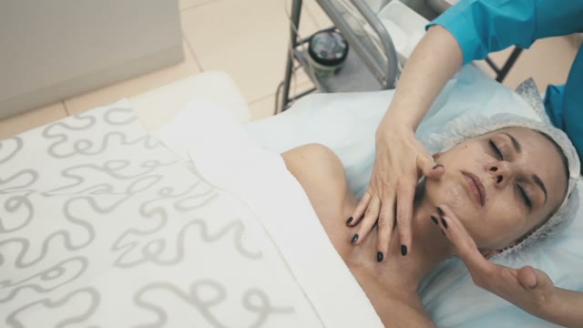 Woman From The Spa Salon Gently Massage The Neck Of A Young Attractive Girl