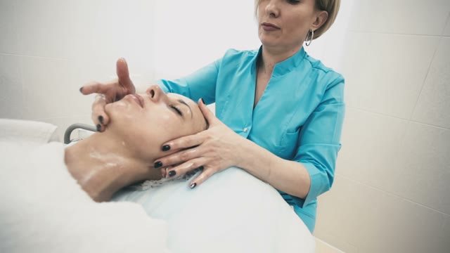 Massage Of A Young Girl's Face With The Help Of Healing Creams