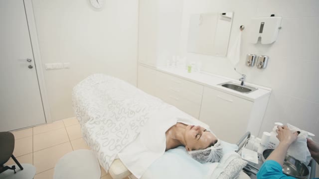 A Salon Worker Removes The Cream From Her Face With Napkins