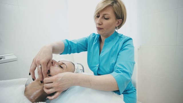 Woman From The Spa Salon Ennobles The Face Of A Young Beautiful Girl
