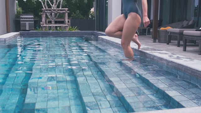Girl In A Swimsuit Descends Into The Pool