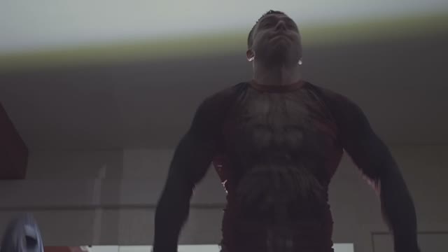 Man Lifts A Barbell Above His Head