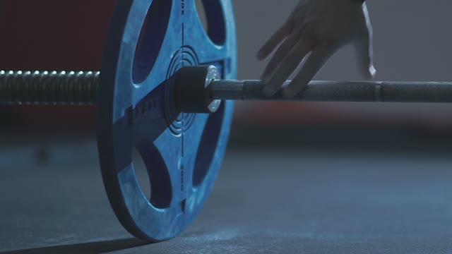 Man Takes The Barbell With His Hands