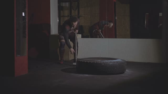 Man Beats A Sledgehammer In A Rubber Wheel