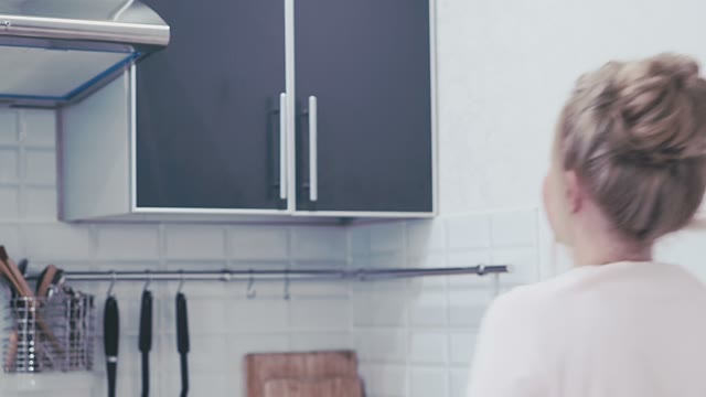Woman Takes An Empty Mug From The Cupboard