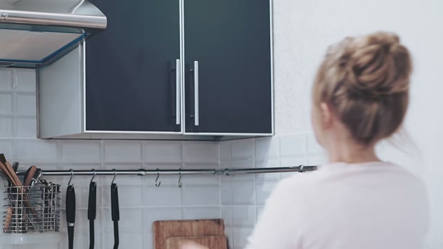 Woman Opens The Cupboard And Takes Out The Mug