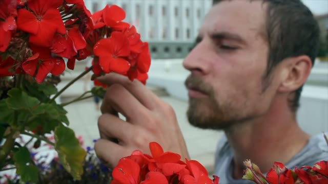 Guy With A Skateboard Is Sniffing A Flower