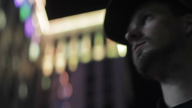 Face Of A Man Against The Background Of A Glowing Building Close-up