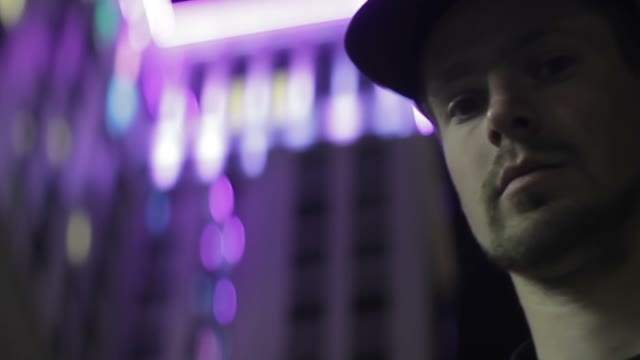 Face Of A Man Against The Background Of A Glowing Building Close-up